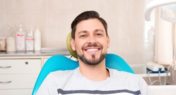 Man smiling in dental chair wearing t shirt