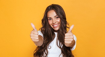 Woman with an attractive smile giving thumbs up