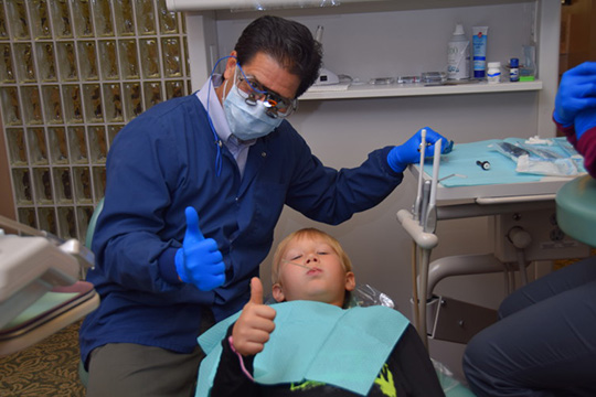 Dr. Lloyd and smiling kid in dental chair
