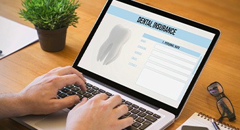 Patient filling out dental insurance form on computer