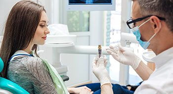 Male dentist showing a dental implant to a patient