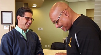 Dr. Lloyd and patient laughing by reception desk