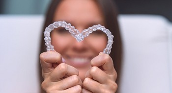 Patient making a heart with her clear aligners