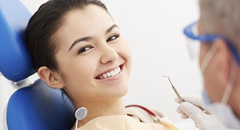 Smiling woman receiving dental exam