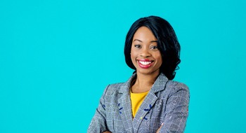confident woman in business attire standing against blue background