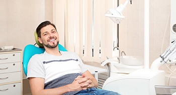 Hombre con cabello castaño sonriendo en el sillón dental