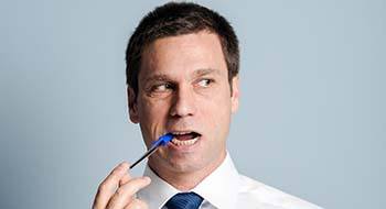 Man chewing on pen headed for a dental emergency in Daytona Beach