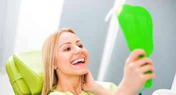 Woman smiling while looking into the green mirror