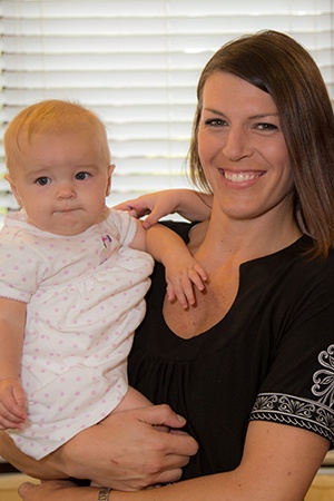 Young woman and infant smiling at dental office