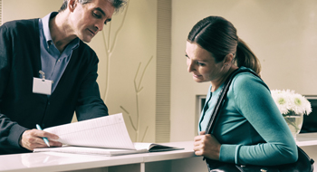 Woman reviewing insurance forms at the dentist