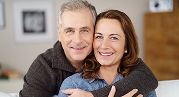 A middle-aged couple smiling after completing dental implant post-op instructions in Daytona Beach