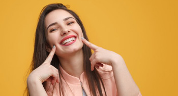 Woman pointing to her healthy smile