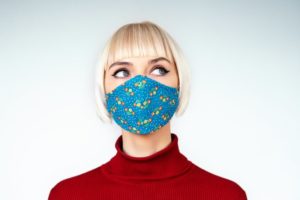 Woman wearing mask, concerned about gum disease and COVID-19