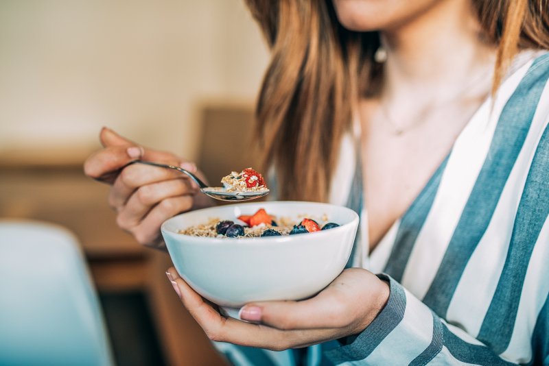 person with dentures eating oatmeal