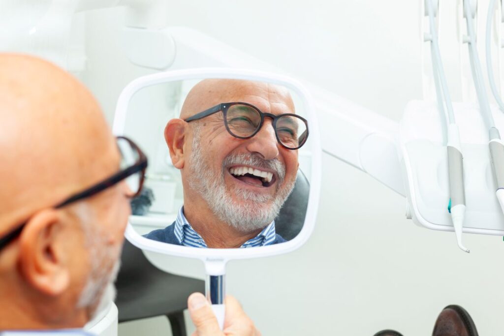 A man looking at his smile in the mirror