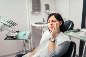 Woman in dentist chair with pain from dry socket