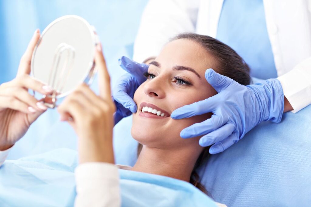 A woman looking at her new smile at the dentist
