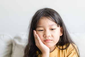 Close-up of little girl with jaw pain